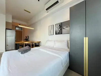 a bedroom with a large white bed and a table at The Colony By Infinitum N in Kuala Lumpur