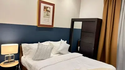 a bedroom with a bed with a blue wall at Comfy 2BR with FREE Parking at Neu Suites by OKBnB in Kuala Lumpur