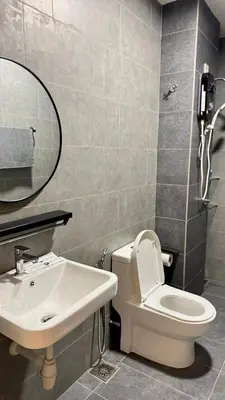 a bathroom with a sink and a toilet and a mirror at Comfy 2BR with FREE Parking at Neu Suites by OKBnB in Kuala Lumpur