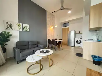 a living room with a couch and a table and a kitchen at The Colony By Infinitum C in Kuala Lumpur