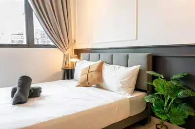 a bedroom with a bed with a plant and a window at The Colony By Infinitum S in Kuala Lumpur