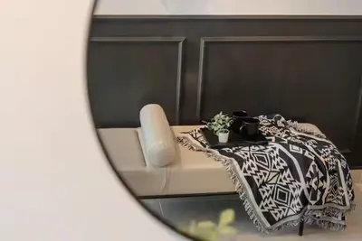 a mirror reflection of a couch with a table and a plant at The Colony By Infinitum S in Kuala Lumpur