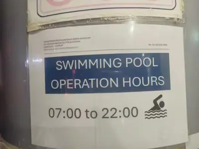 a sign that says swimming pool operation hours at The Colony By Infinitum S in Kuala Lumpur