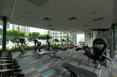 a gym with rows of tread machines in a building at Mercu Summer Suites Bernice KLCC in Kuala Lumpur
