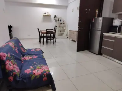 a living room with a couch and a kitchen at Regalia Suites in Kuala Lumpur