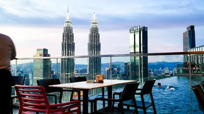 a table and chairs on a balcony with the petronas towers at Imperial Residence Kuala Lumpur in Kuala Lumpur