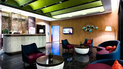 a lobby with chairs and a table and a bar at Imperial Residence Kuala Lumpur in Kuala Lumpur