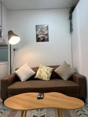 a living room with a brown couch and a coffee table at Cozy mercu summer suite 5mint WD KLCC luxury apartment free wifi, netfliix in Kuala Lumpur