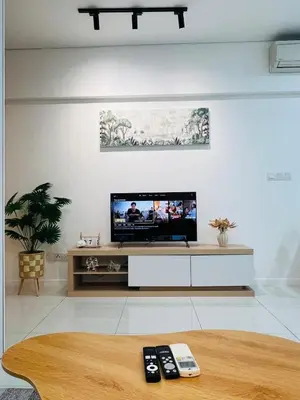 a living room with a tv and remote controls at Cozy mercu summer suite 5mint WD KLCC luxury apartment free wifi, netfliix in Kuala Lumpur