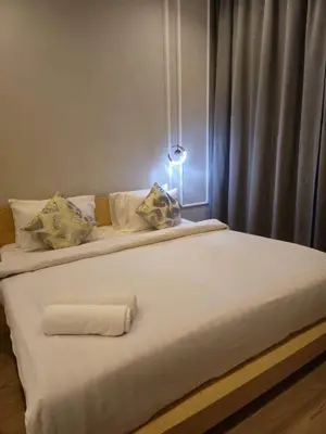 a bed with white sheets and pillows in a room at Lucentia Residence by Infinity swimming pool,lalaport KL in Kuala Lumpur