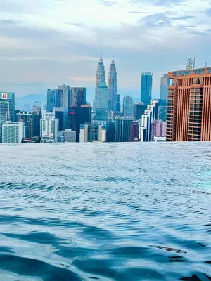 a view of a city skyline from the water at Lucentia Residence by Infinity swimming pool,lalaport KL in Kuala Lumpur