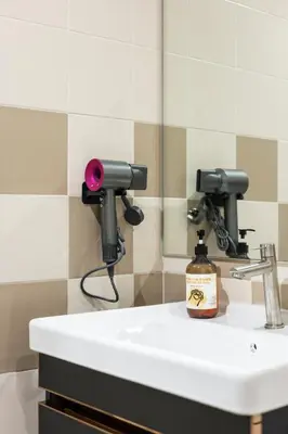 a bathroom sink with a soap dispenser and a mirror at Royal Domain KL near Mont Kiara by Sleepy Bear in Kuala Lumpur