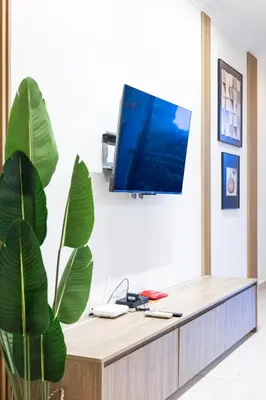 a living room with a tv on a wall at Royal Domain KL near Mont Kiara by Sleepy Bear in Kuala Lumpur