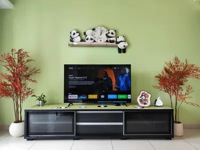 a flat screen tv sitting on top of a entertainment center at Suasana Bukit Ceylon with Panda Themes KL Tower View in Kuala Lumpur