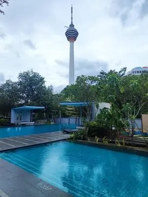a swimming pool with a tv tower in the background at Suasana Bukit Ceylon with Panda Themes KL Tower View in Kuala Lumpur