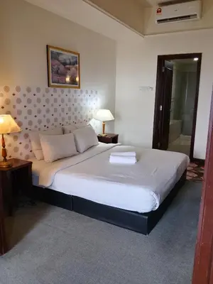 a bedroom with a large white bed with two pillows at Afrin Service Suits at Berjaya Times Square in Kuala Lumpur