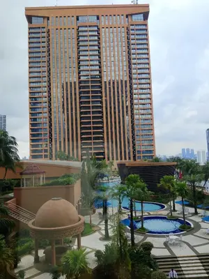 a view of a resort with two pools and a large building at Afrin Service Suits at Berjaya Times Square in Kuala Lumpur