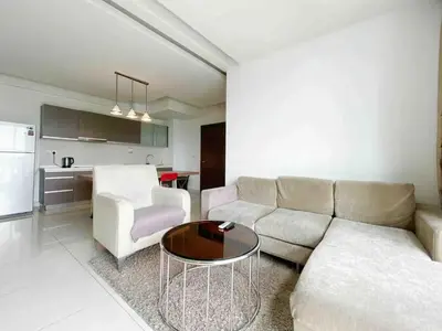 a living room with a couch and a table and a kitchen at Regalia Studio apartment in Kuala Lumpur
