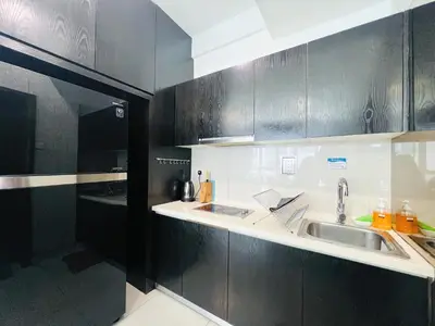 a kitchen with two sinks and black cabinets at Regalia Studio apartment in Kuala Lumpur