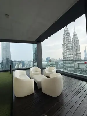 a balcony with white chairs and a view of the city at Star Residance KLCC by Nexus in Kuala Lumpur