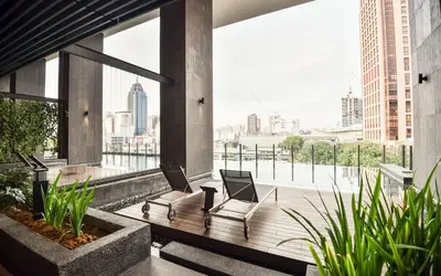 a balcony with two chairs and a view of the city at Anggun Residence KLCC by Airhost in Kuala Lumpur