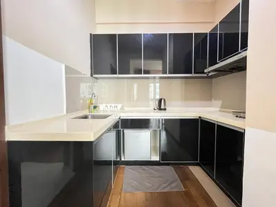 a kitchen with black and white cabinets and a sink at Homestay Walking Distance to PWTC in Kuala Lumpur