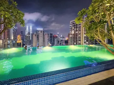 a large swimming pool with a city skyline at night at Majestic Residence Infinity Pool with KLCC View in Kuala Lumpur