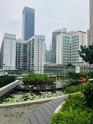 a city skyline with tall buildings and a pond with lilies at Axon Suite near Pavilion KL by Sky in Kuala Lumpur