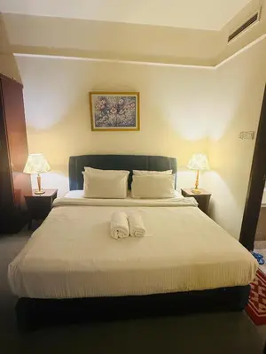 a bedroom with a bed with two towels on it at Times Square Service Suites By Humira in Kuala Lumpur