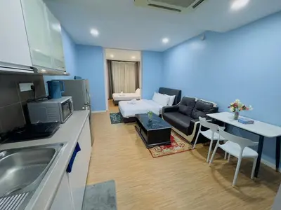 a kitchen and living room with a couch and a table at STANDARD HOME Taragon Puteri Bintang in Kuala Lumpur