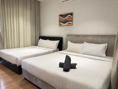two beds in a hotel room with a hat on them at Quill Residence by Infinity pool in Kuala Lumpur