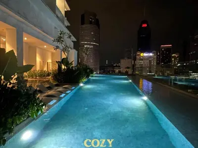 a swimming pool with a city skyline at night at Quill Residence by Infinity pool in Kuala Lumpur