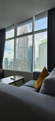 a bedroom with a view of a city from a window at Sky Suites KLCC by Global Family Suites in Kuala Lumpur