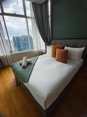 a bedroom with a large bed with a large window at Sky Suites KLCC by Global Family Suites in Kuala Lumpur