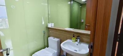 a bathroom with a toilet and a sink and a mirror at Sky Suites KLCC by Global Family Suites in Kuala Lumpur