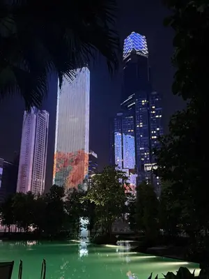 a lit up city skyline at night with a green fountain at \u5409\u9686\u5761\u96c5\u5c45\u4e50\u5929\u6c47Agile\u56db\u6708\u516c\u5bd3 in Kuala Lumpur