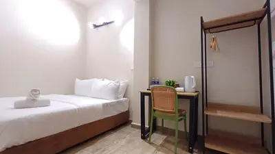 a bedroom with a bed and a desk with a chair at Swing and Pillows - ICC Pudu Kuala Lumpur in Kuala Lumpur