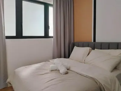 a bed with white sheets and pillows in a room at M Vertica Elegant Stay in Cheras in Kuala Lumpur