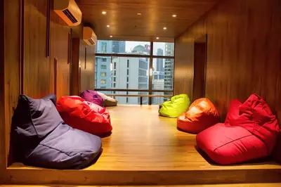a room with four colorful bean bags on a wooden floor at Tribeca Homestay Bukit Bintang TRX in Kuala Lumpur