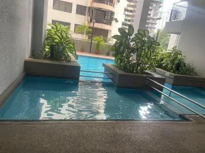 a swimming pool in the middle of a building with plants at Grand suites at Seri Bukit Ceylon in Kuala Lumpur