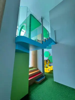 a room with a staircase with green flooring at Chic Cityscape Homestay in Bukit Bintang 1-5 people in Kuala Lumpur