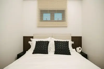 a bed with black and white pillows and a window at Chic Cityscape Homestay in Bukit Bintang 1-5 people in Kuala Lumpur