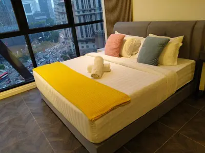 a bed in a room with a large window at Scarletz Suites KLCC by WHM in Kuala Lumpur