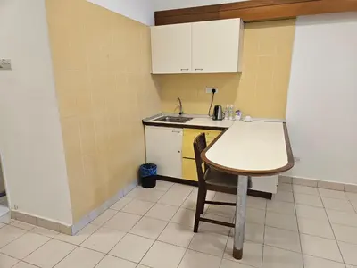 a small kitchen with a table and a sink at Menara PGRM Suites By VG Homes in Kuala Lumpur