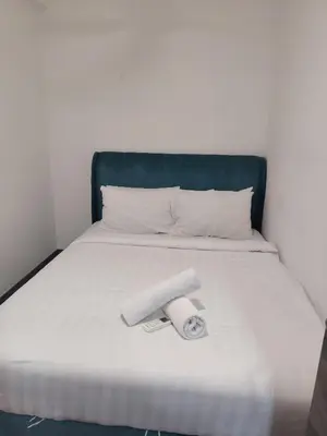 a bed with a roll of toilet paper on it at Agile Delima Homestay Premium Suites at TRX BUKIT BINTANG in Kuala Lumpur