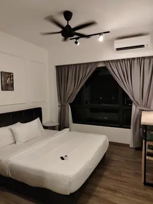 a bedroom with a bed with a ceiling fan and a window at Agile Delima Homestay Premium Suites at TRX BUKIT BINTANG in Kuala Lumpur