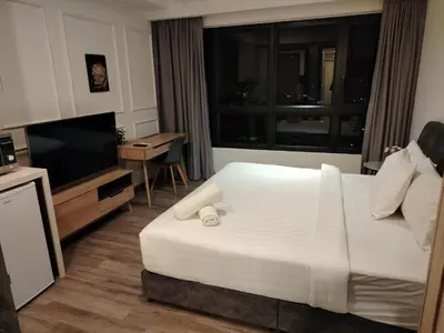 a hotel room with a bed and a television at Agile Delima Homestay Premium Suites at TRX BUKIT BINTANG in Kuala Lumpur