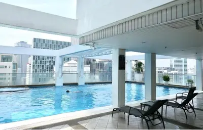 a large swimming pool in a building with chairs at Park view apartment klcc with city view in Kuala Lumpur