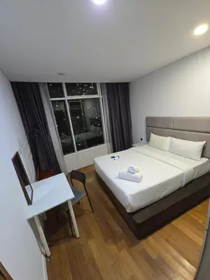 a bedroom with a bed and a desk and a window at Park view apartment klcc with city view in Kuala Lumpur