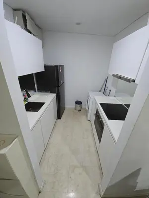 a kitchen with white counters and a black refrigerator at Park view apartment klcc with city view in Kuala Lumpur